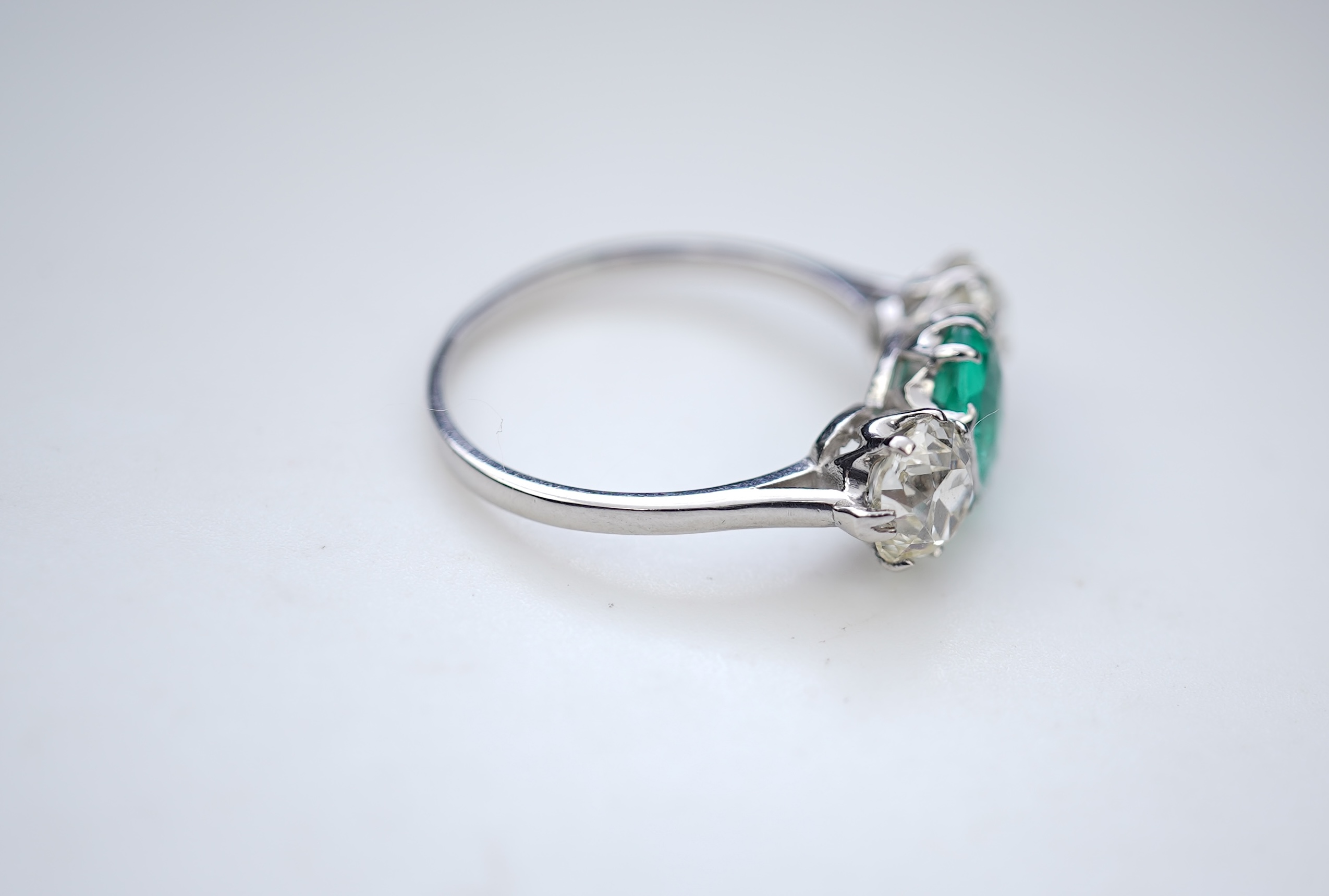 An attractive emerald and diamond three-stone ring, early 20th century